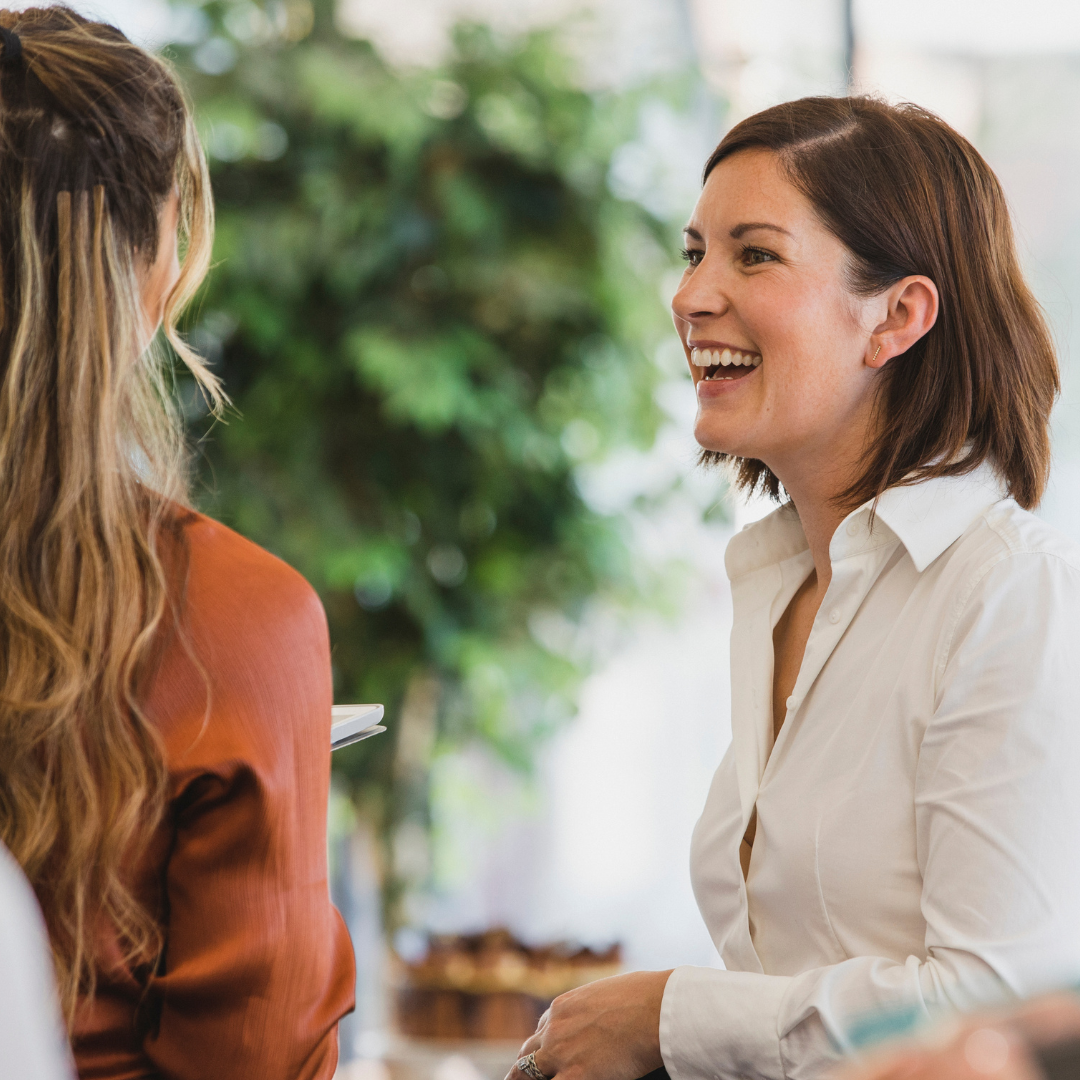 Woman cheerfully talking to colleague at and event